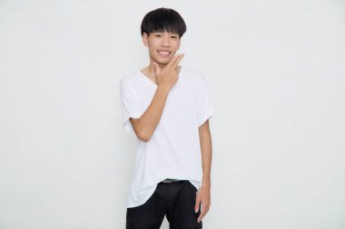 Beyaz arka planda izole edilmiş günlük beyaz tişört stüdyosundaki gülümseyen yakışıklı Asyalı adam.