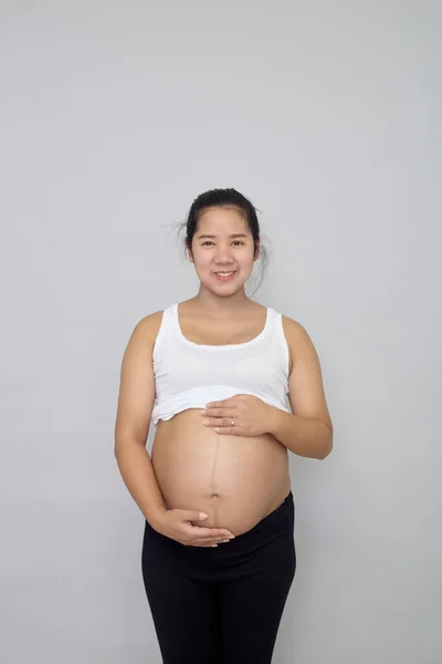 Gülümseyen Hamile Asyalı Kadın Gri Arka Planda Karnına Dokunuyor — Stok fotoğraf
