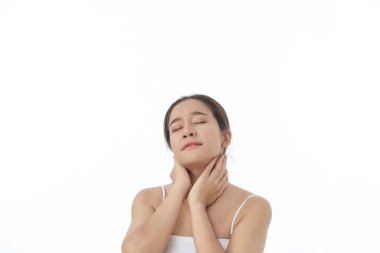 Temiz tenli genç ve güzel Asyalı kız beyaz arka planda masada oturan kameraya gülümsüyor. Güzellik kaplıcası ve kozmetoloji