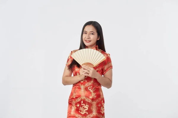 魅力的な美しいです若いアジア人女性で伝統的な赤Chongsamドレス保持中国語ファンのための中国の旧正月でライトグレー隔離されたスタジオの背景 — ストック写真