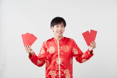 Geleneksel oryantal kostümlü yakışıklı Asyalı adam Çin 'in yeni yıl kavramları için açık gri arka planda izole edilmiş.
