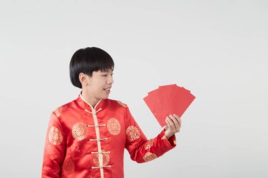 Mandarin yakalı genç bir Asyalı beyaz arka planda kırmızı zarf paketi taşıyor. Çin yeni yıl konsepti.