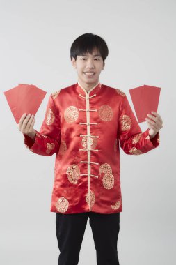 Mandarin yakalı genç bir Asyalı beyaz arka planda kırmızı zarf paketi taşıyor. Çin yeni yıl konsepti.