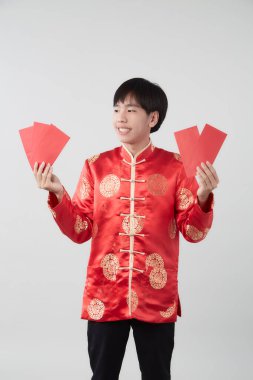 Mandarin yakalı genç bir Asyalı beyaz arka planda kırmızı zarf paketi taşıyor. Çin yeni yıl konsepti.