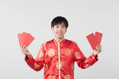 Mandarin yakalı genç bir Asyalı beyaz arka planda kırmızı zarf paketi taşıyor. Çin yeni yıl konsepti.