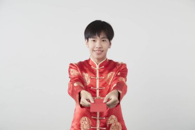 Mandarin yakalı genç bir Asyalı beyaz arka planda kırmızı zarf paketi taşıyor. Çin yeni yıl konsepti.