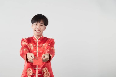 Mandarin yakalı genç bir adam beyaz arka planda kırmızı zarf paketi tutuyor. Çin yeni yıl konsepti.)