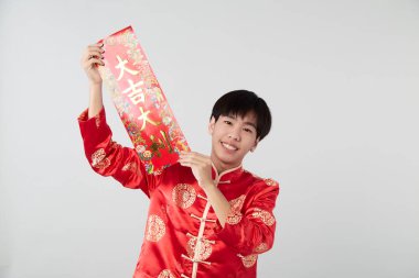 Geleneksel oryantal kostüm giymiş Asyalı bir adam Çin 'de yeni yıl kavramları için açık gri arka planda başarılı olmak adına Çince tebrikleri ve en iyi dileklerimi sunar.