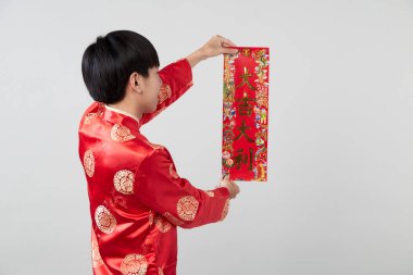 Geleneksel oryantal kostüm giymiş Asyalı bir adam Çin 'de yeni yıl kavramları için açık gri arka planda başarılı olmak adına Çince tebrikleri ve en iyi dileklerimi sunar.