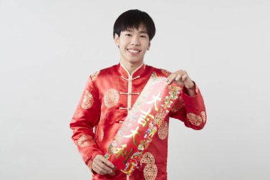 Geleneksel oryantal kostüm giymiş Asyalı bir adam Çin 'de yeni yıl kavramları için açık gri arka planda başarılı olmak adına Çince tebrikleri ve en iyi dileklerimi sunar.