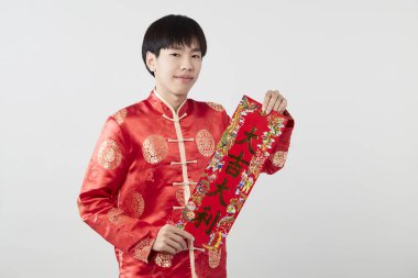 Geleneksel oryantal kostüm giymiş Asyalı bir adam Çin 'de yeni yıl kavramları için açık gri arka planda başarılı olmak adına Çince tebrikleri ve en iyi dileklerimi sunar.