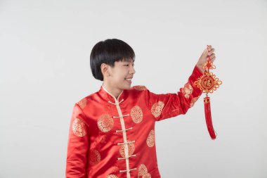 Geleneksel kıyafetleri olan Doğulu bir gencin portresi Çin 'de yeni yıl kavramları için açık gri arka planda başarılı olmak adına Çince' deki şanslı sözcüğü kutluyor ve en iyi dileklerimi sunuyorum.