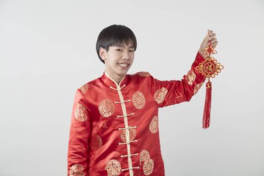 Geleneksel kıyafetleri olan Doğulu bir gencin portresi Çin 'de yeni yıl kavramları için açık gri arka planda başarılı olmak adına Çince' deki şanslı sözcüğü kutluyor ve en iyi dileklerimi sunuyorum.