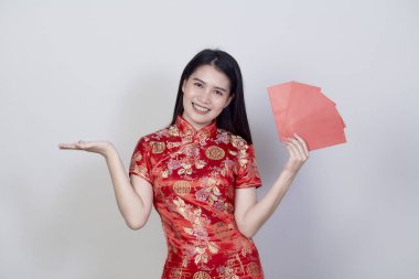 Güzel Asyalı bir kadının portresi kırmızı bir Çin elbisesi taşıyor. Parasal bir hediye. Mutlu yıllar.