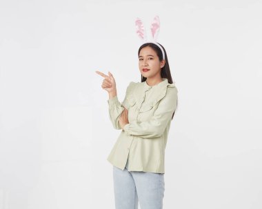 Şenlikli tavşan ve yumurta mevsimi. Paskalya tavşanı kulaklı güzel Asyalı kadın portresi. Beyaz arka planda Paskalya bayramı.