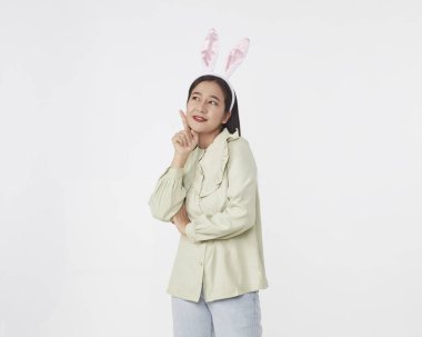 Şenlikli tavşan ve yumurta mevsimi. Paskalya tavşanı kulaklı güzel Asyalı kadın portresi. Beyaz arka planda Paskalya bayramı.