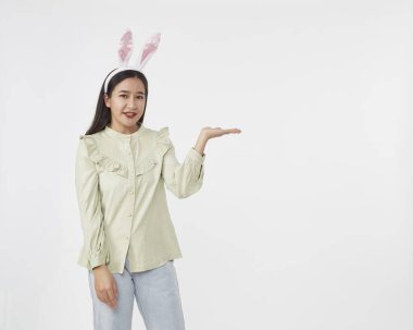 Şenlikli tavşan ve yumurta mevsimi. Paskalya tavşanı kulaklı güzel Asyalı kadın portresi. Beyaz arka planda Paskalya bayramı.