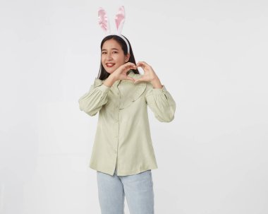 Şenlikli tavşan ve yumurta mevsimi. Paskalya tavşanı kulaklı güzel Asyalı kadın portresi. Beyaz arka planda Paskalya bayramı.