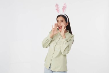 Şenlikli tavşan ve yumurta mevsimi. Paskalya tavşanı kulaklı güzel Asyalı kadın portresi. Beyaz arka planda Paskalya bayramı.