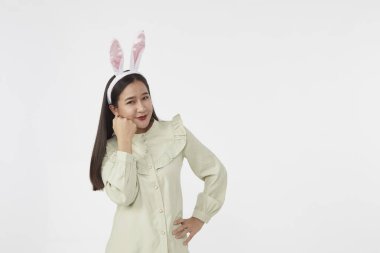 Şenlikli tavşan ve yumurta mevsimi. Paskalya tavşanı kulaklı güzel Asyalı kadın portresi. Beyaz arka planda Paskalya bayramı.