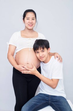 Interesting Asian couple, happy pregnant mother and father isolated on white background, International family day