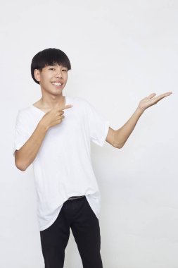 Yakışıklı genç Asyalı bir adam kameraya bakıp gülümserken elini beyaz arka planda gösteriyordu.