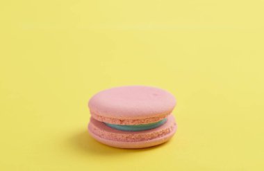 Parlak sarı arkaplan üzerinde pembe fransız badem kurabiyesi veya badem kurabiyesi metin için kopyalama alanı