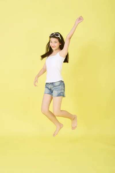 아리따운 아시아 소녀의 모습밝은 노란색 배경에 공중에서 행복하고 — 스톡 사진
