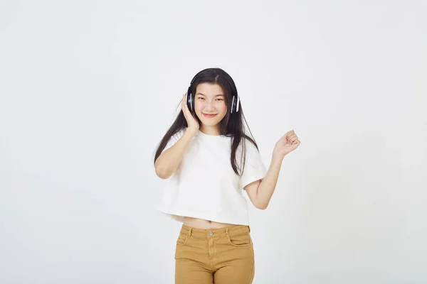 年轻的亚洲女人 戴着耳机 穿着白色背景的舞蹈 — 图库照片