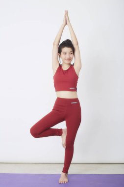 Genç Asyalı kadın arka planda egzersiz yapıyor.