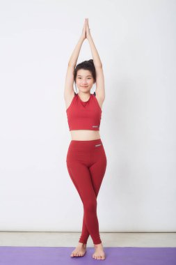 Genç Asyalı kadın arka planda egzersiz yapıyor.