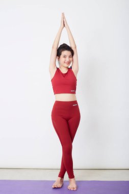 Genç Asyalı kadın arka planda egzersiz yapıyor.