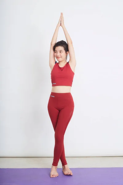 Young Asian woman exercise over light background