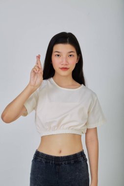 Genç Asyalı esmer kadın şans dilemek için şans diliyor beyaz arka planda izole edilmiş.