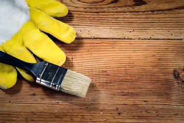 Ahşap arka planda eldivenler ve fırça