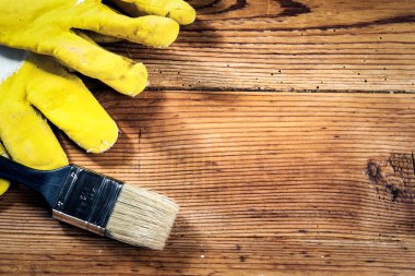 Ahşap arka planda eldivenler ve fırça