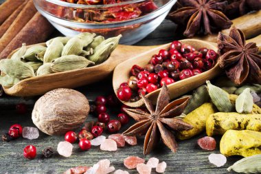 Ahşap masa, anason, himalaya tuzu, tarçın, kırmızı biber, kakule, paprika, zerdeçal ve hindistan cevizi, seçici odak