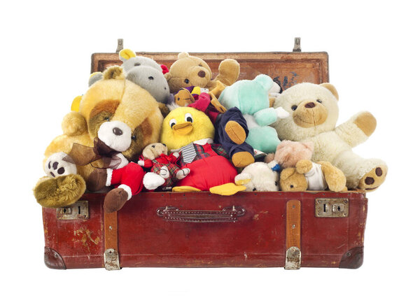 Игрушки в старом чемодане, изолированные на белом фоне