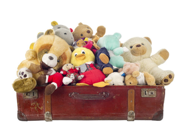 Игрушки в старом чемодане, изолированные на белом фоне