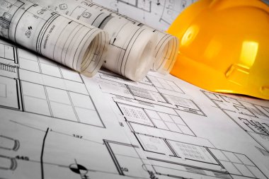 İnşaat planları ve planlar masanın üstünde.