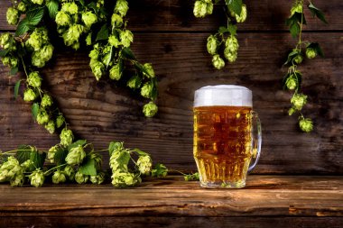 Bir bardak bira ve ahşap arka planda zıplamalar.