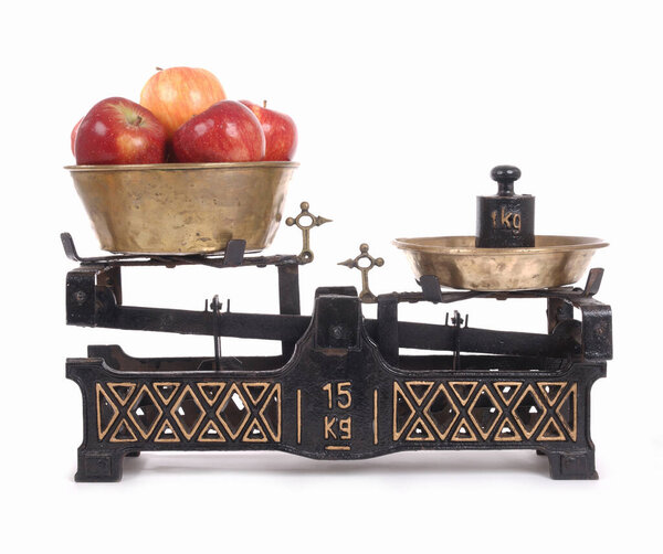 Old-fashioned balance scale with apples isolated on white background
