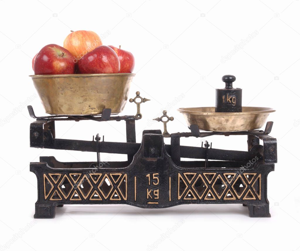 Old-fashioned balance scale with apples isolated on white background