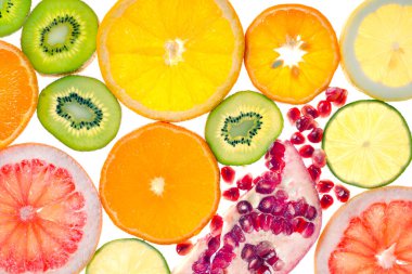 Beyaz arka planda turunçgil, nar ve kivi şeklinde daireler şeklinde taze kesilmiş.