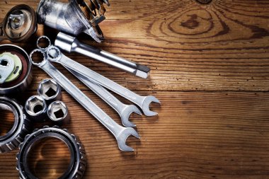 Ahşap arkaplanda araçlar ve eski otomobil parçaları