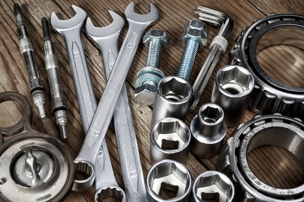 Ahşap arkaplanda araçlar ve eski otomobil parçaları