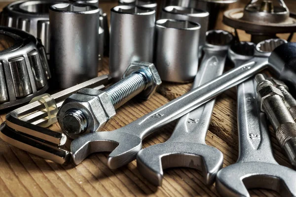 tools and old auto parts on wooden background