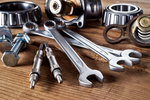 tools and old auto parts on wooden background