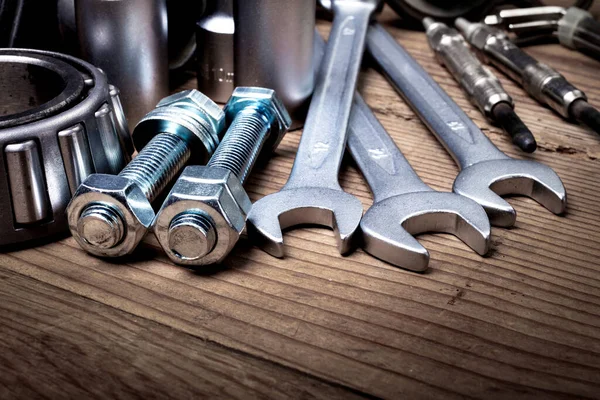 tools and old auto parts on wooden background