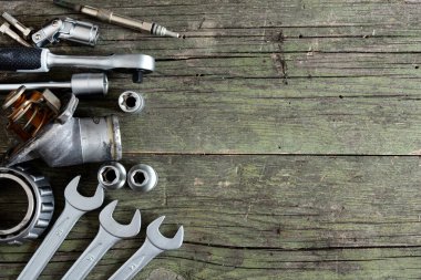 Ahşap arkaplanda araçlar ve eski otomobil parçaları